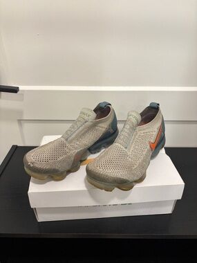 Nike Women’s Slip-On Flyknit Sneakers in Light Beige with Orange Swoosh